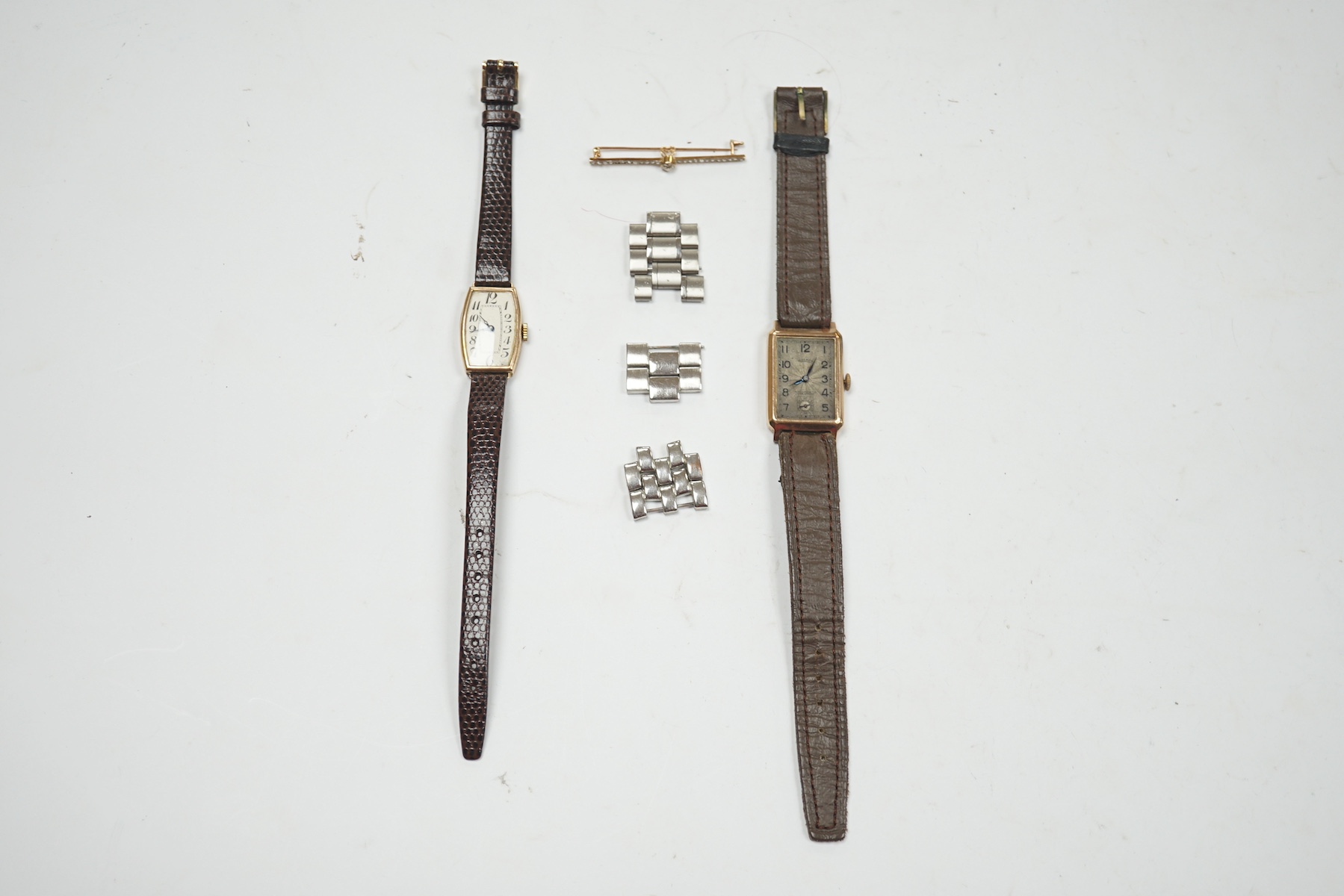 An early 20th century yellow metal and diamond cluster set bar brooch, 45mm, together with two 9ct gold cased manual wind wrist watches and assorted steel watch links. Condition - poor to fair